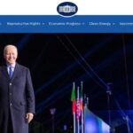 President Joe Biden walking before a crowd of spectators.